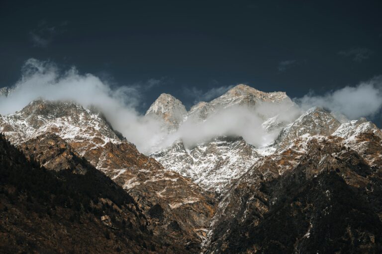 Stunning view of snow-covered Himalayan mountains with clouds and dramatic sky.